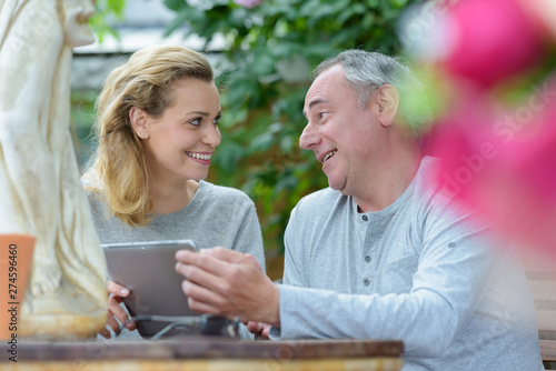 happy couple using digital tablet outdoors