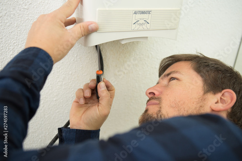 electrician fitting a thermostat system