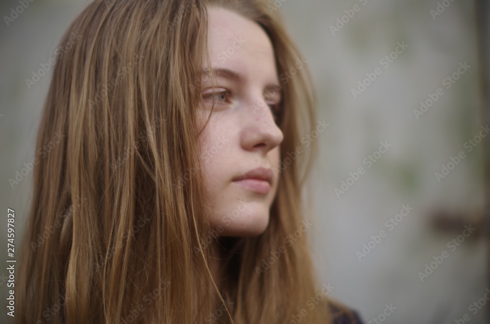beautiful young blonde with long flowing hair on a blurry background beautiful young blonde with long flowing hair on a blurry background