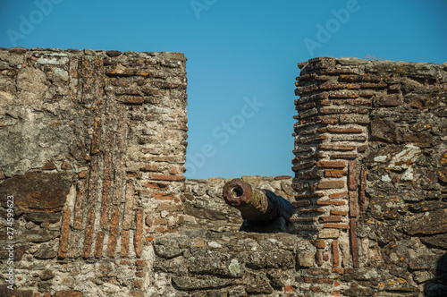 Rusty iron cannon at crenel in the stone wall of Marvao