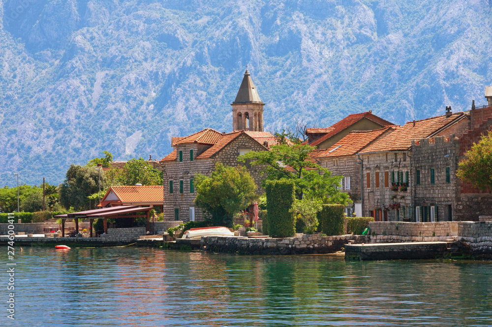 Small seaside village in the background of the mountains. Montenegro, Adriatic Sea. View of Bay of Kotor and Stoliv village on sunny summer day Small seaside village in the background of the mountains. Montenegro, Adriatic Sea. View of Bay of Kotor and Stoliv village on sunny summer day
