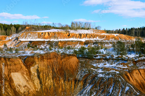 View from the mountain to the red sand in the snow of a small canyon. This place is located in the Minsk region, the village of Praleski, mining quarry Radashkovichi. This snowy scene was photographed photo