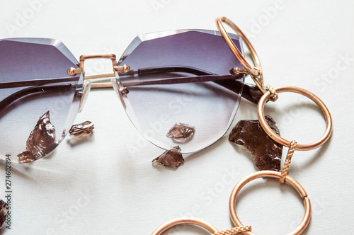 Sunglases. Fashionable summer spectacles, jewelry. Background