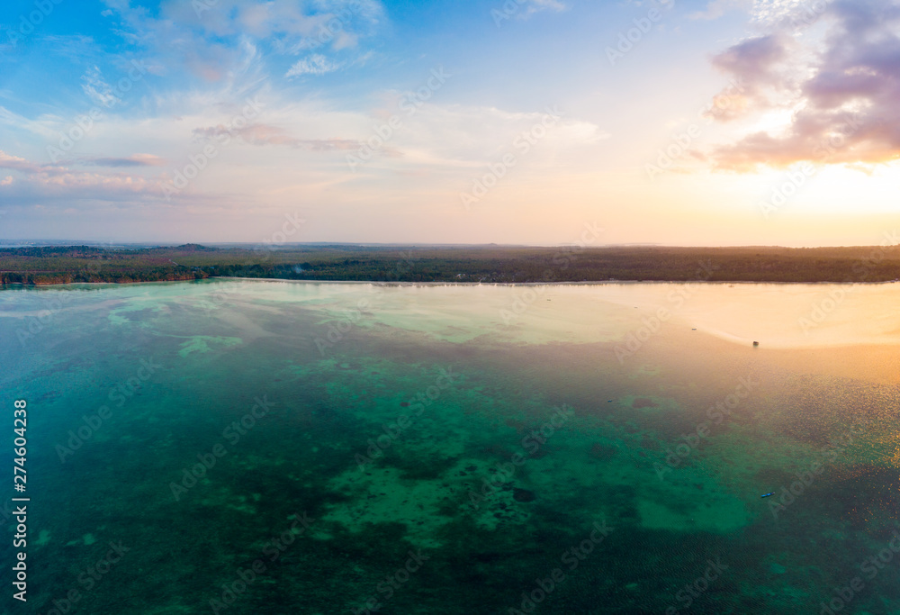 Fototapeta premium Aerial view tropical beach island reef caribbean sea dramatic sky at sunset sunrise. Indonesia Moluccas archipelago, Kei Islands, Banda Sea. Top travel destination, diving snorkeling