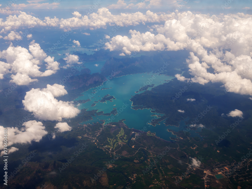 Top view landscape Island mountain and coast with blue sea ocean and white clouds. View from airplane while flying over Andaman sea in Thailand.