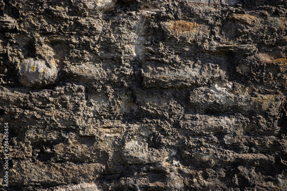 Old rough weathered stone wall texture