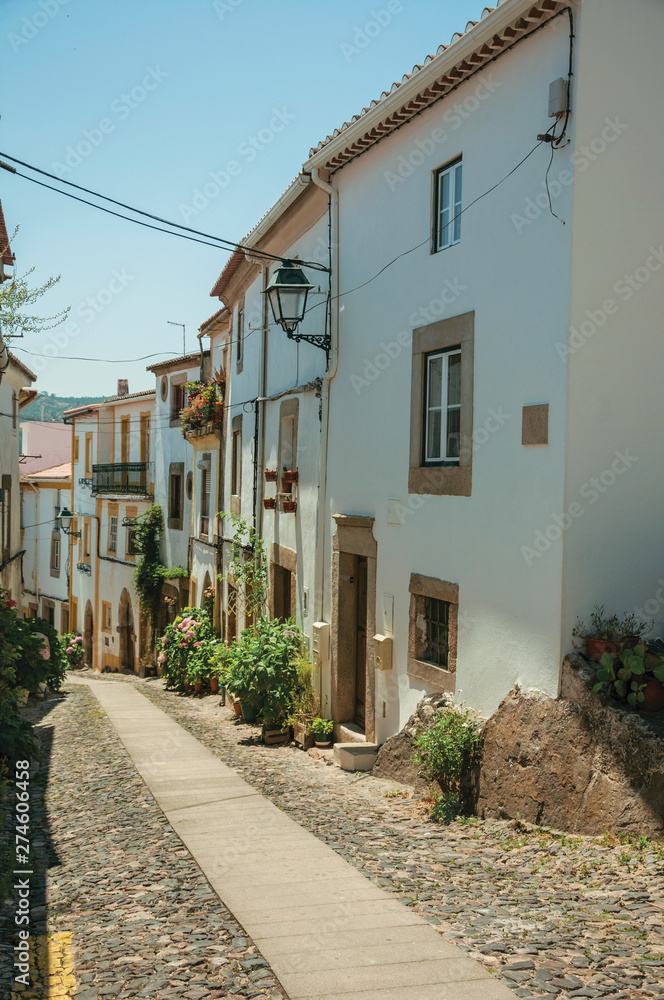Old houses with whitewashed wall in an alley on slope