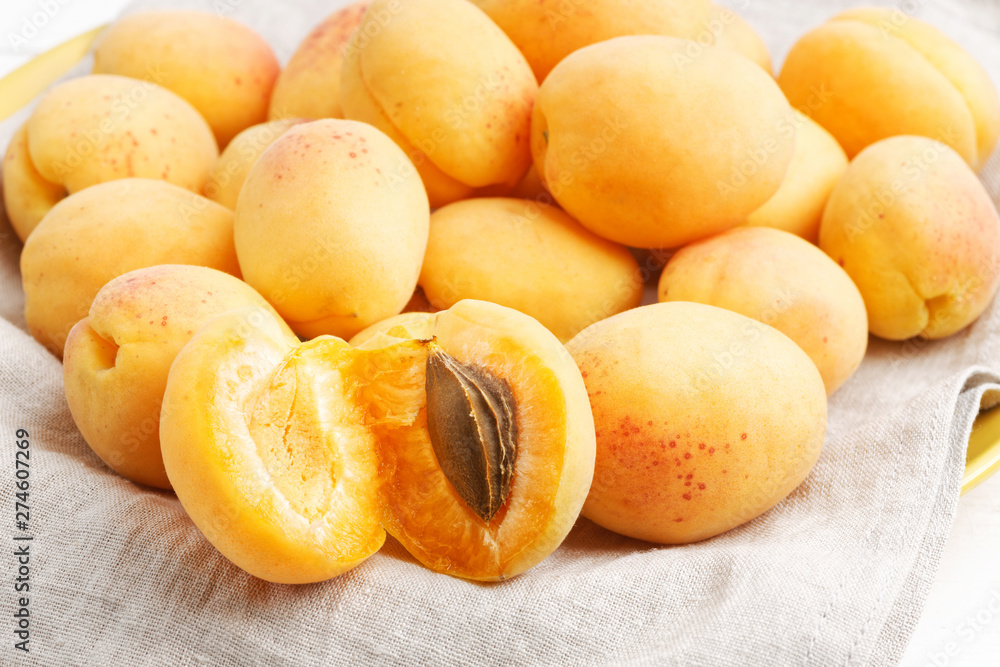 Closeup image of ripe apricot fruits on a cloth napkin. Shallow focus. Closeup image of ripe apricot fruits on a cloth napkin. Shallow focus.