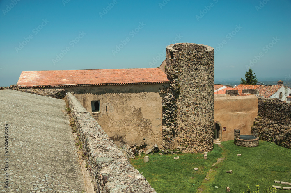 Lawn on castle central courtyard among stone walls and tower
