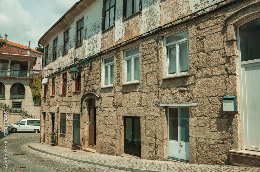 Old houses with stone wall in a deserted alley