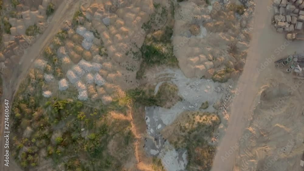 Construction site with heaps of sand and land on a summer evening at sunset. Aerial view. Wasteland for building buildings. Torn soil Construction site with heaps of sand and land on a summer evening at sunset. Aerial view. Wasteland for building buildings. Torn soil