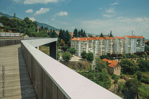 Footbridge over valley with apartment building and trees
