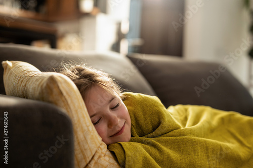 Cute little girl napping on the sofa at home.