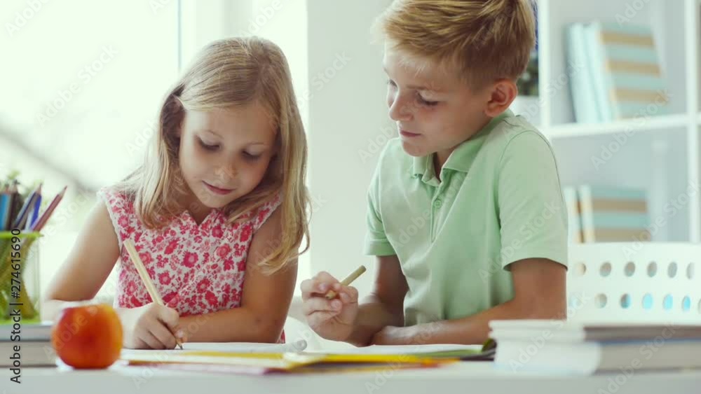 Cute schoolchildren doing homework together Cute schoolchildren doing homework together
