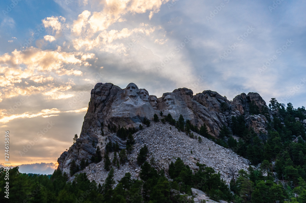 A dramatically colorful sky developing around sunset behind the four US presidents of Mount Rushmore, in North Dakota.