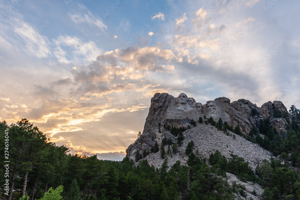 A dramatically colorful sky developing around sunset behind the four US presidents of Mount Rushmore, in North Dakota.