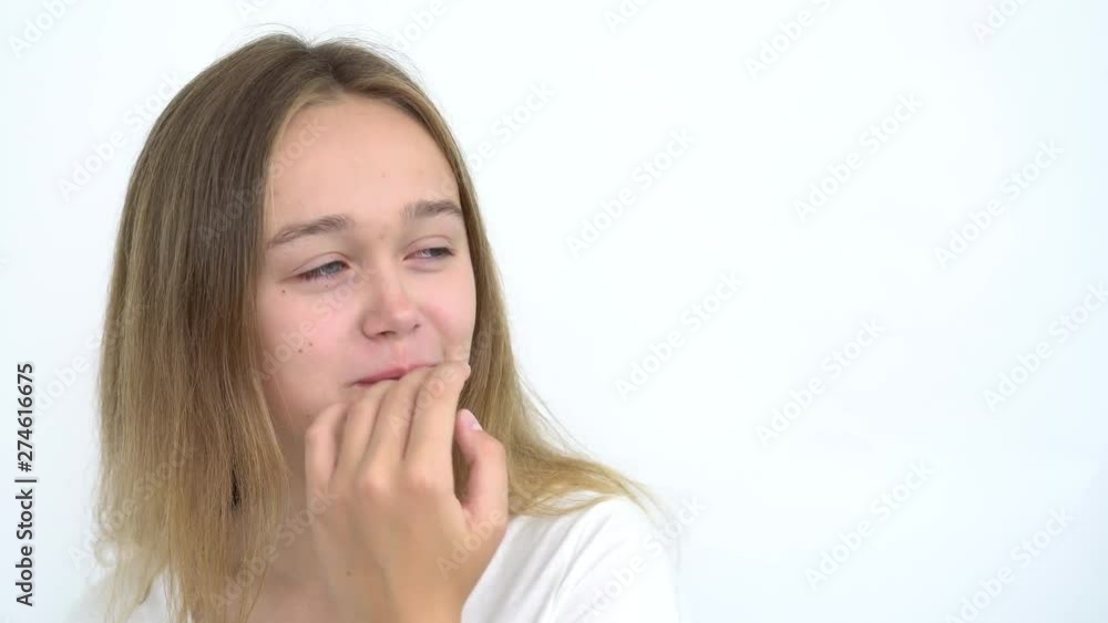 close-up of a pretty cute teen girl with long hair who eats a big green apple on a white background close-up of a pretty cute teen girl with long hair who eats a big green apple on a white background