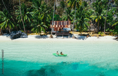 Fotografie Couple enjoying time kayaking in front of the beach in Coron