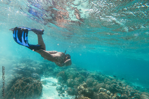 Beautiful woman swimming underwater in a tropical sea full of corals. under water shot with action camera. concept about wanderlust travels