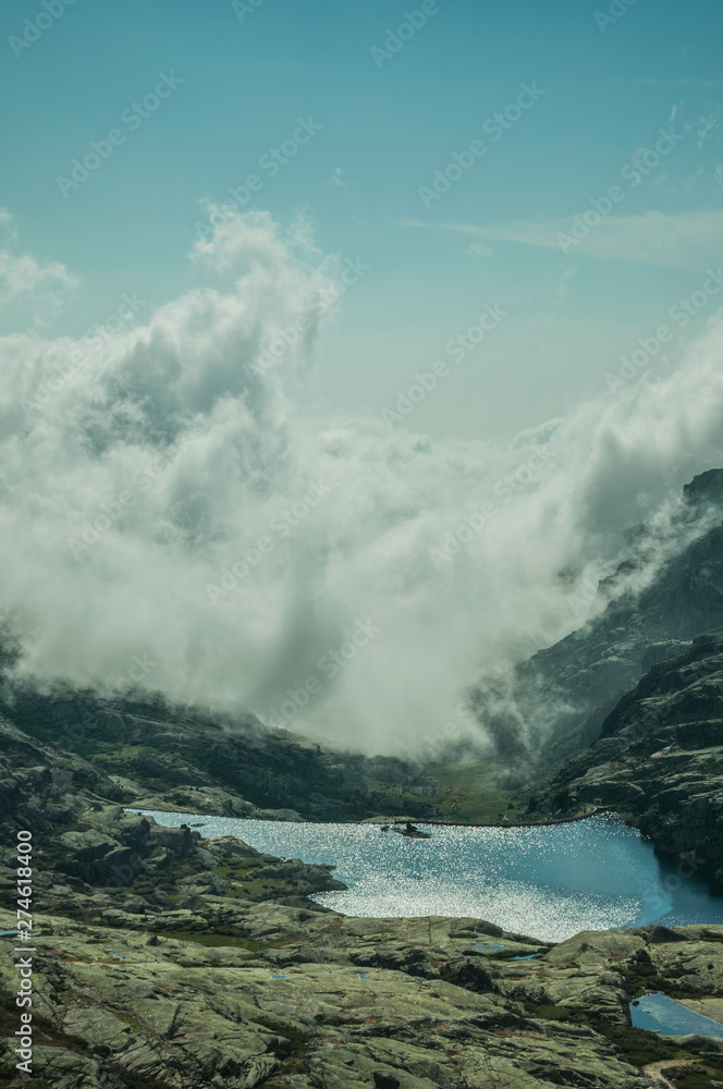 Obraz premium Hilly landscape with clouds coming from the ravine