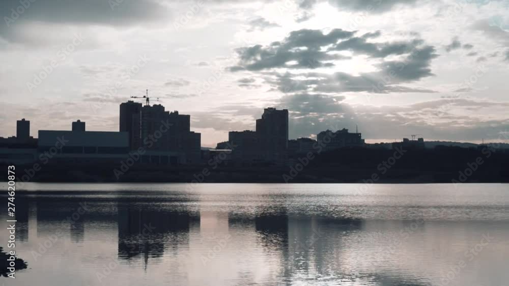 Silhouette of the city on the river bank. Clouds above the city. Cityscape and beautiful sunset. Silhouette of the city on the river bank. Clouds above the city. Cityscape and beautiful sunset.