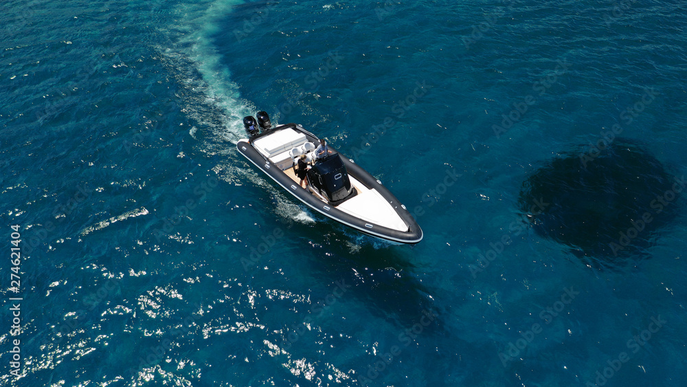 Naklejka premium Aerial photo of inflatable rib speed boat cruising in high speed deep blue sea of Mykonos island, Cyclades, Greece