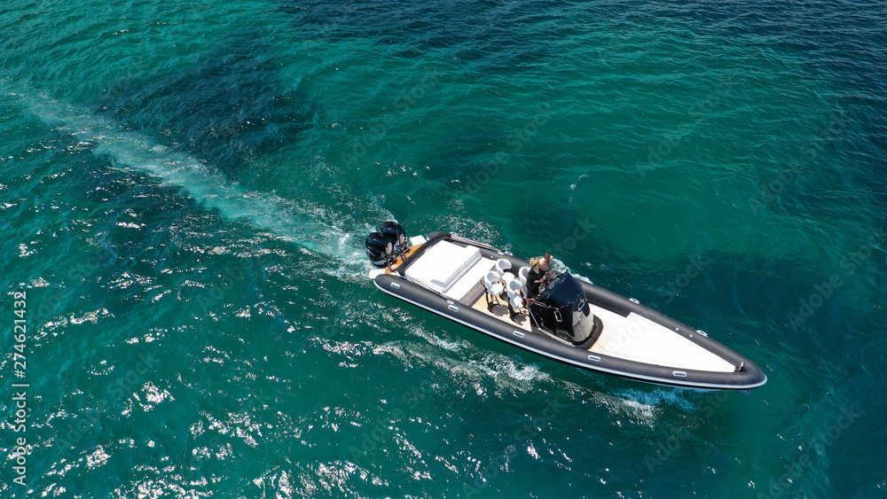 Fototapeta premium Aerial photo of inflatable rib speed boat cruising in high speed deep blue sea of Mykonos island, Cyclades, Greece