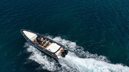 Aerial photo of inflatable rib speed boat cruising in high speed deep blue sea of Mykonos island, Cyclades, Greece
