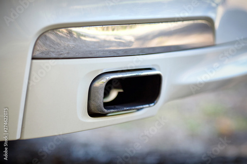 Low angle view of the exhaust pipe of a car with selective focus on tailpipe
