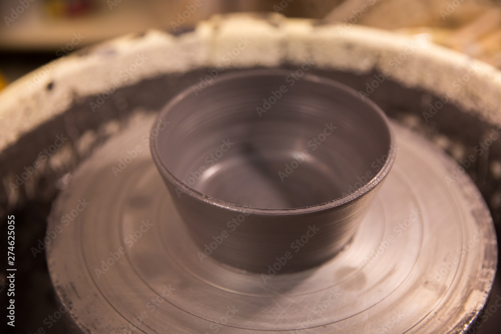 Vase from fresh clay turn twirl potters wheel. Sculptor in workshop makes jug out of clay closeup Vase from fresh clay turn twirl potters wheel. Sculptor in workshop makes jug out of clay closeup