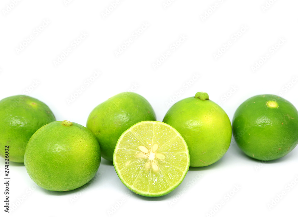 Cut fresh lime with whole fruits rowed up on white background