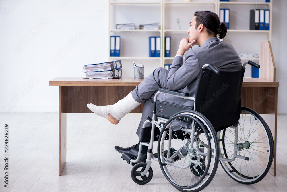 Male employee in wheel-chair in the office 