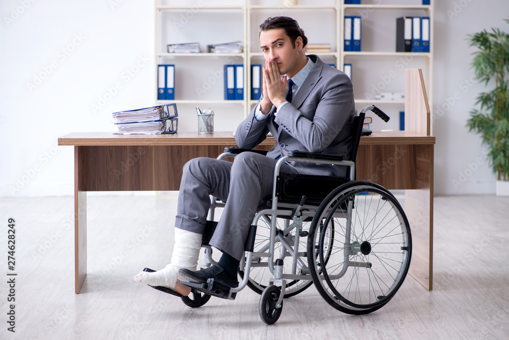 Male employee in wheel-chair in the office Male employee in wheel-chair in the office