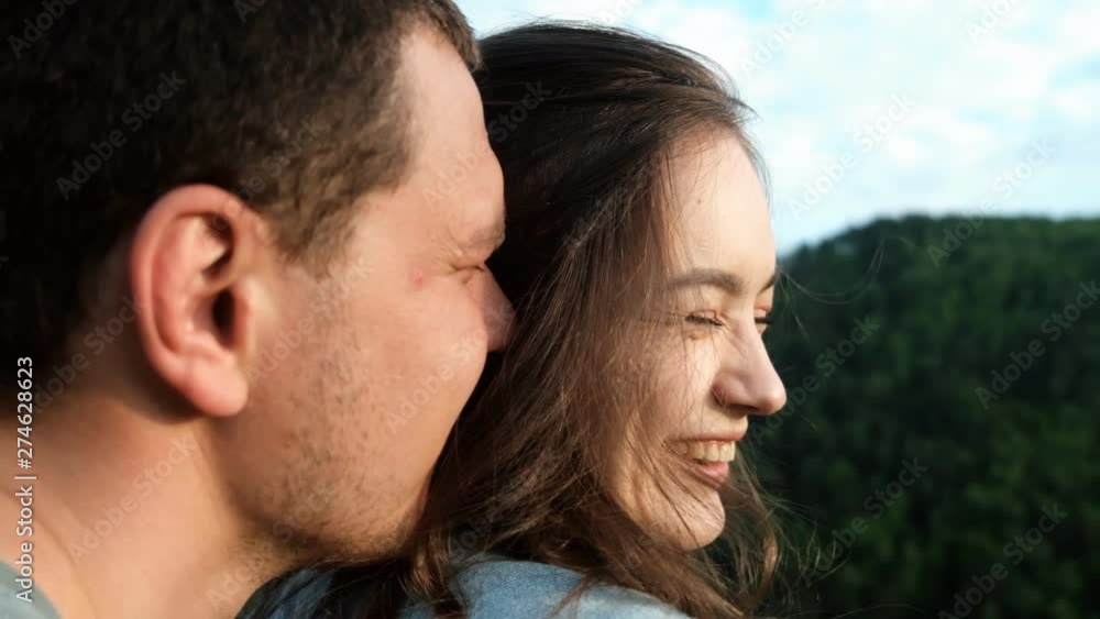A young woman smiles happily in the arms of her boyfriend. A young woman smiles happily in the arms of her boyfriend.