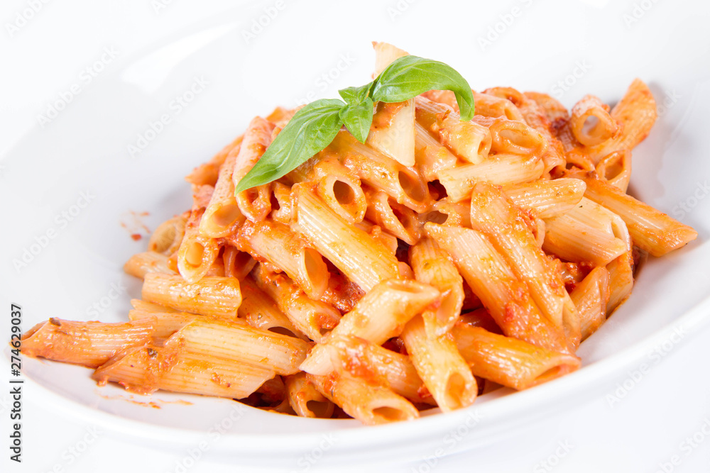 Penne with pesto rosso and sun dried tomatoes decorated with basil Penne with pesto rosso and sun dried tomatoes decorated with basil