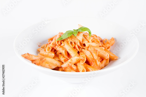 Penne with pesto rosso and sun dried tomatoes decorated with basil	
