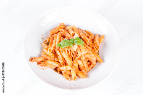Penne with pesto rosso and sun dried tomatoes decorated with basil 