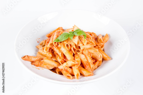 Penne with pesto rosso and sun dried tomatoes decorated with basil 
