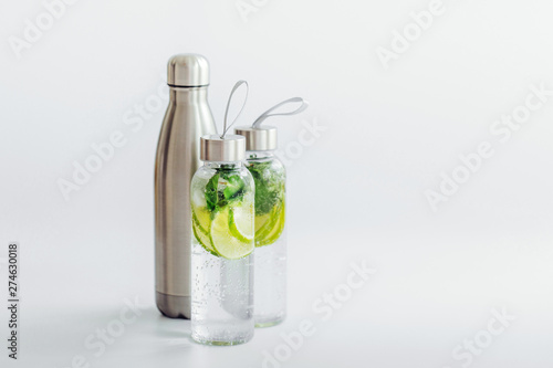 Fresh lime and mint infused water, cocktail, detox drink, lemonade in reusable bottles. Summer drinks. Health care concept.