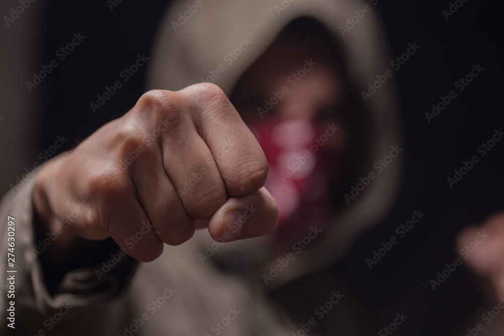 close up view of fist of a hooded men