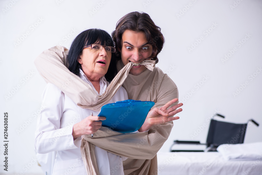 Old female psychiatrist visiting young male patient Old female psychiatrist visiting young male patient