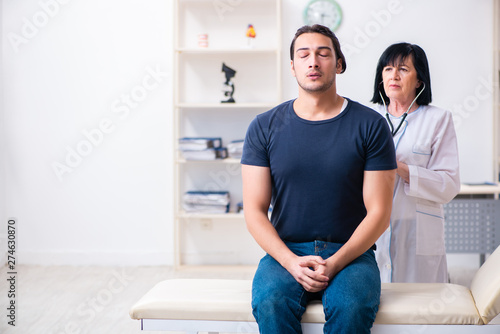 Young male patient visiting aged female doctor 