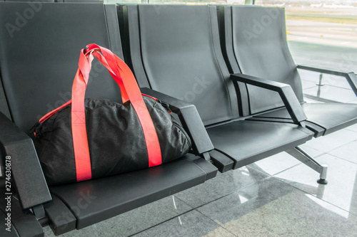 Suspicious black sport bag left on chairs unattended. Lost luggage. Concept of safety in public places and terrorism