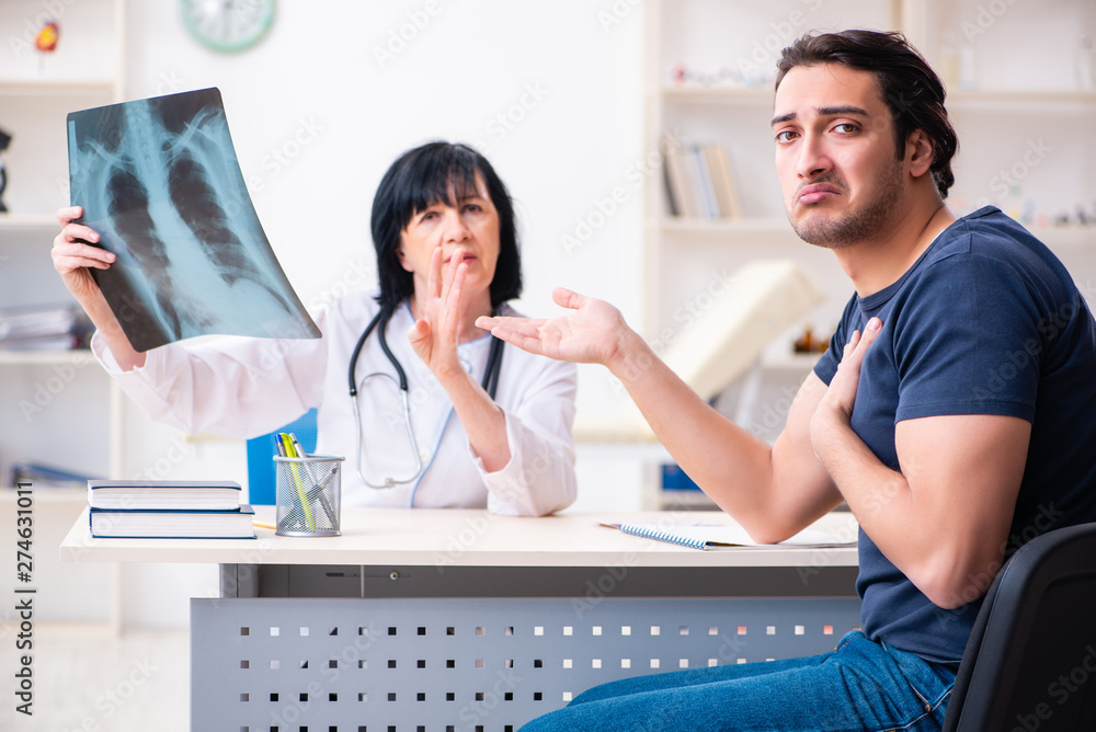 Obraz premium Young male patient visiting aged female doctor 