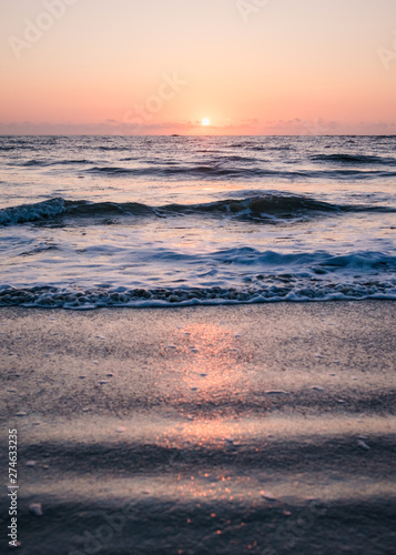 Sun Rising Over Clouds Lining the Ocean Horizon