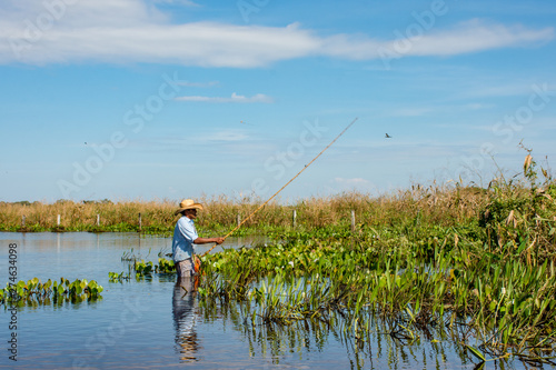 Pescador solitario dentro da agua na natureza