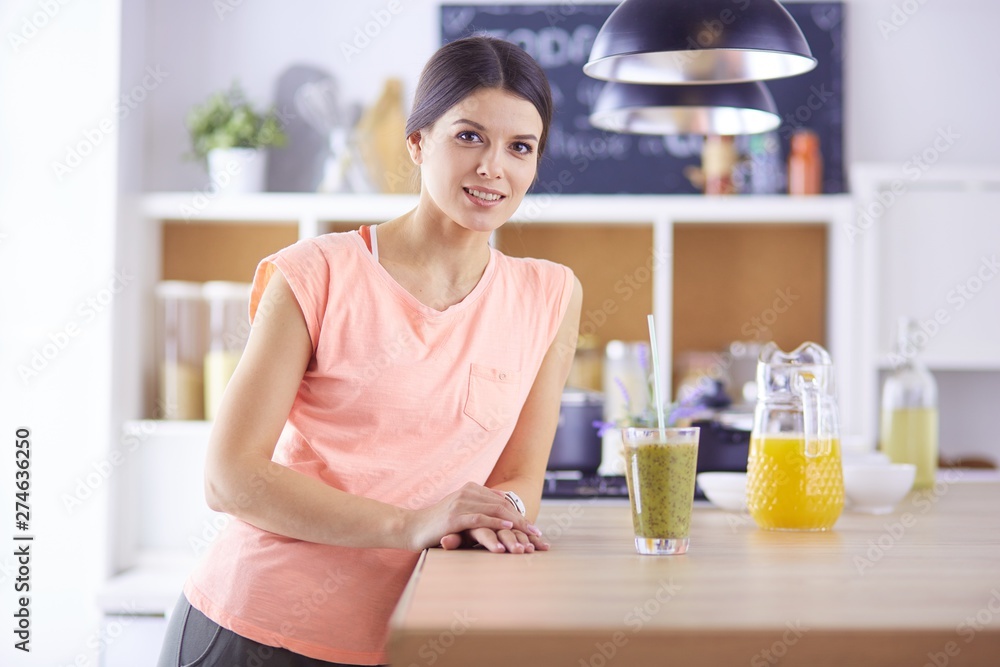 Young woman sitting a table in the kitchen Young woman sitting a table in the kitchen