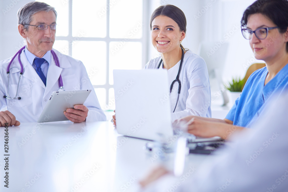 Serious medical team discussing patient's case in a bright office Serious medical team discussing patient's case in a bright office