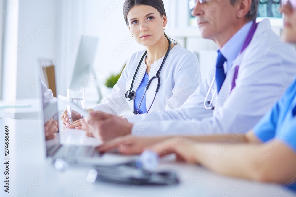 Doctors consulting with each other in a hospital conference room Doctors consulting with each other in a hospital conference room