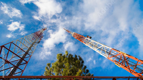 Communications Antenna Towers with Blue Sky and Trees